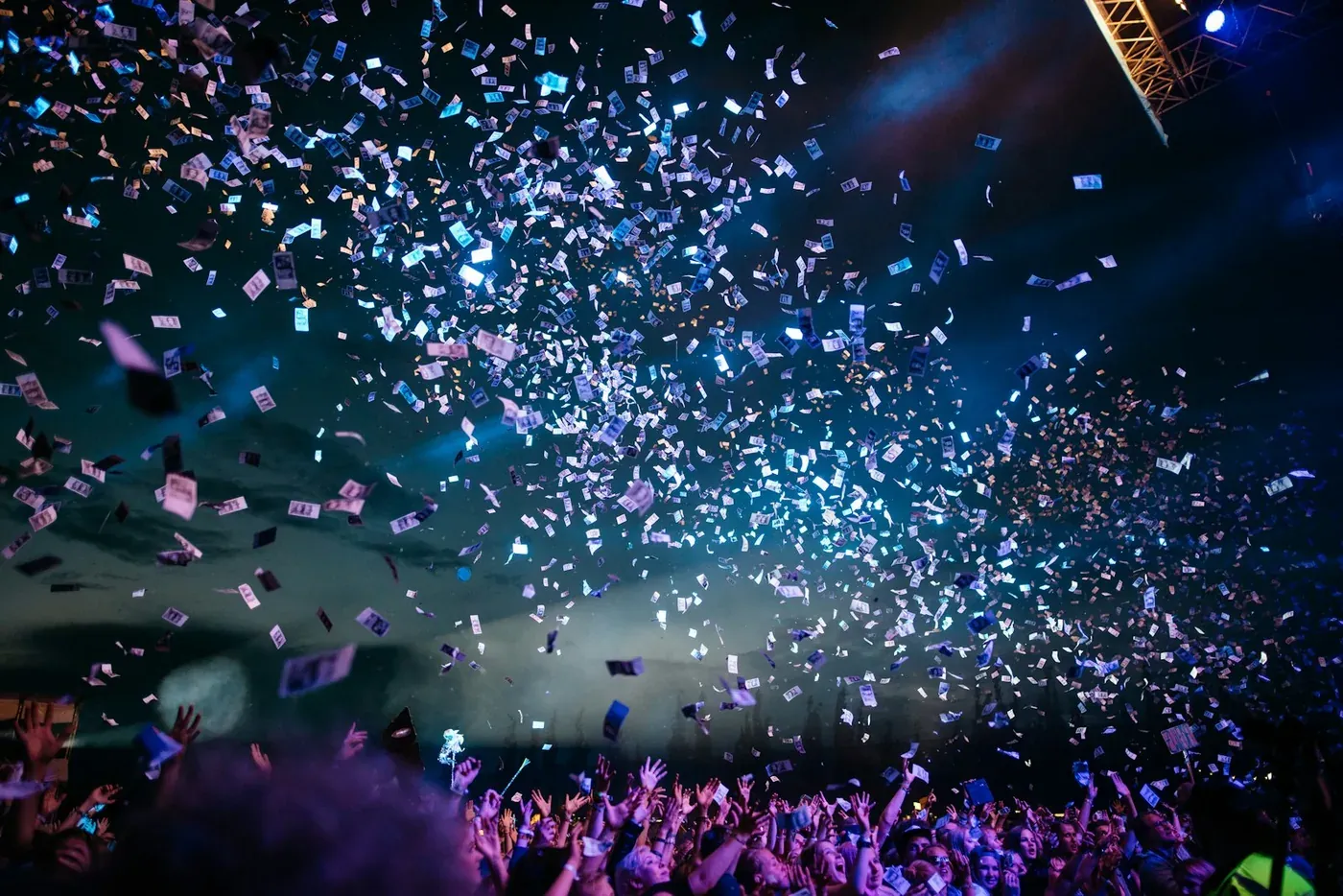A crowd celebrating under confetti and stage lights at a brand activation